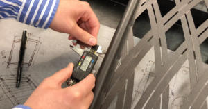 Close up of a man taking exact measurements of a patio chair as part of the BILT Intelligent Instructions design process